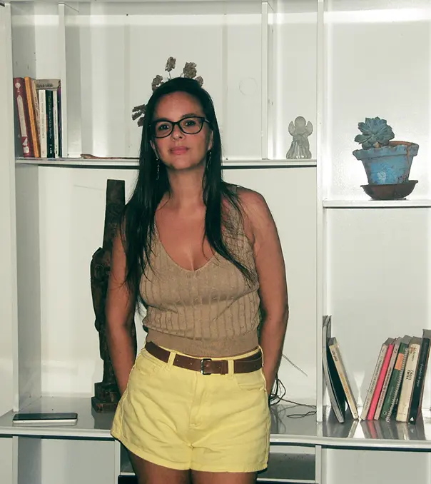 imagem de Nina Goes apioada numa estante de livros
